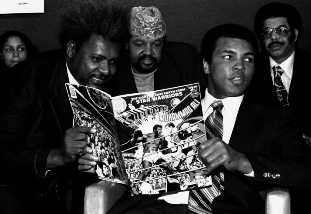 World heavyweight champion Muhammad Ali, right, is shown at a press conference in New York, January 31, 1978, with promoter Don King, left, and Herbert Muhammad, center, to plug a comic book in which he beats Superman. Ali holds a copy of the comic book. (AP Photo/Marty Lederhandler)