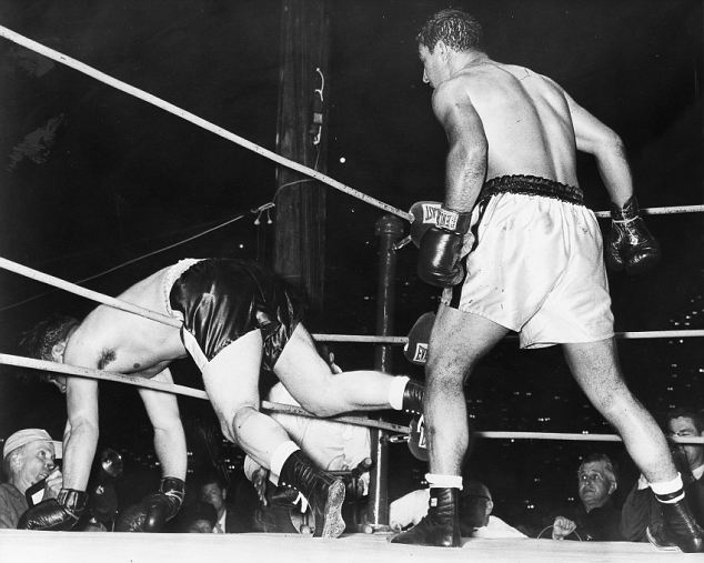 A long right to the chin from Marciano in round eight leaves Cockell draped through the ropes. The champion holds off on this occasion, waiting to see if his opponent will recover. At other times during the fight Marciano wasnt quite so restrained; some observers went so far as to castigate him for flagrant breaches of the rules. He was certainly guilty of more than one low blow, and of hitting Cockell when he was going down. Marciano also butted, elbowed and thumbed his man, all with impunity. 16 May 1955