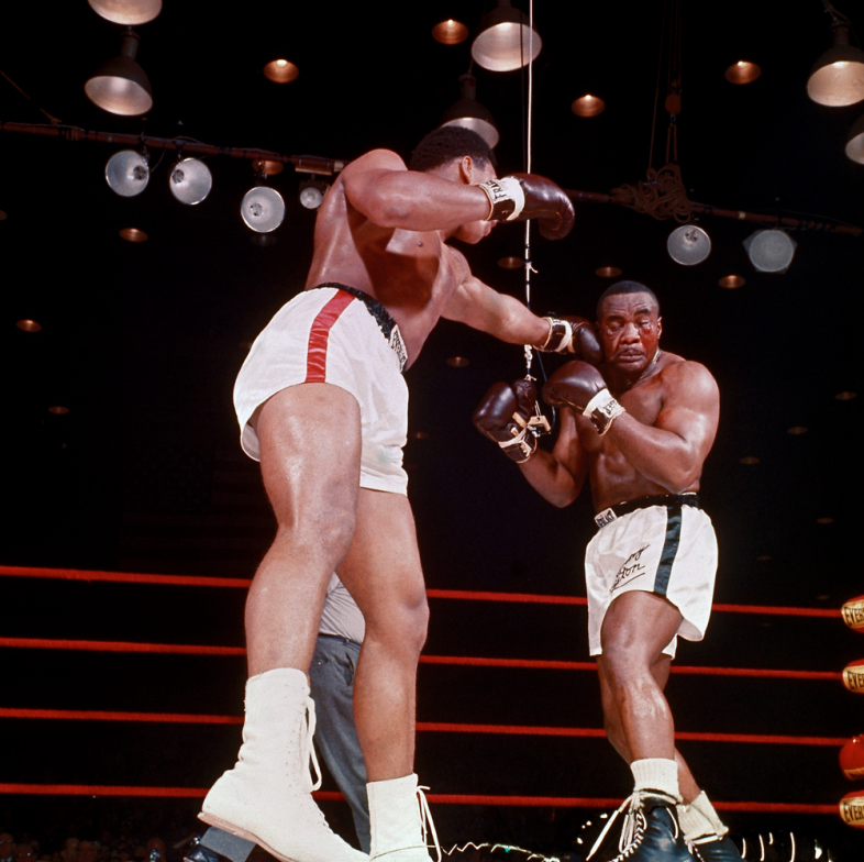 Boxer Muhammad Ali, aka Cassius Clay (R), punching Sonny Liston during heavyweight championship bout.