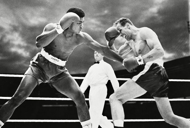 Cassius Clay and Henry Cooper slug away in their first meeting.