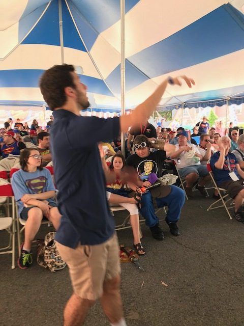 Alexander Rinaldi throwing prizes out to audience during Superman Jeopardy game