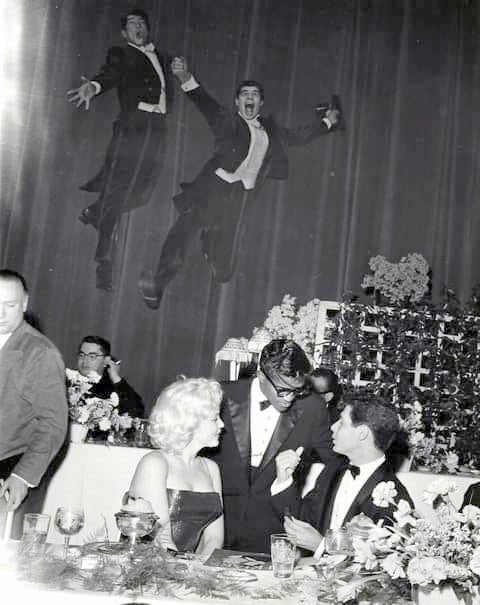 Dean Martin and jerry Lewis are flying in the air while Marilyn Monroe chats with Sammy Davis Jr and Eddie Fisher at the Friars Club – 1955