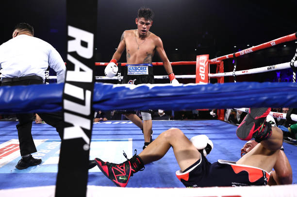KISSIMMEE, FLORIDA – APRIL 24: Emanuel Navarrete knocks-down Christopher Diaz during their fight for the WBO featherweight title at the Silver Spurs Arena on April 24, 2021 in Kissimmee, Florida. 