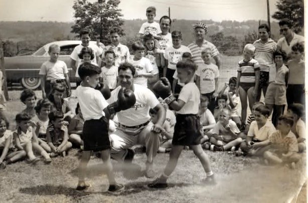 Heavyweight Champion Rocky Marciano teaching some youngsters how to box.