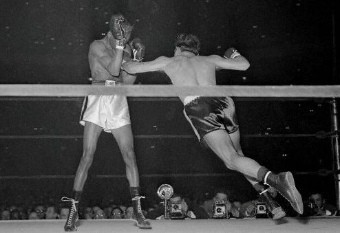 Willie Pep (R) throws a lunging left hook at Sandy Saddler (L) as Sandy Saddler covers up in 4th round of their featherweight title bout at Madison Square Garden on February 11, 1949. Pep won unanimous decision.