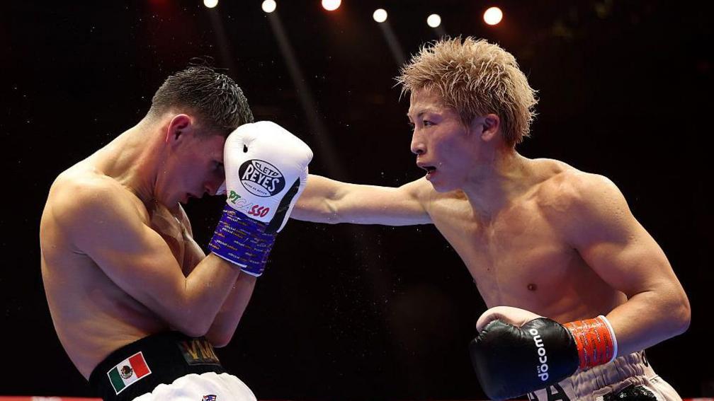 Naoya Inoue (R) scores a vicious right to Picasso's jaw.