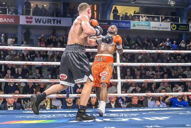 Jacob Bank (L) sends William Scull (R) heading to the canvas with a left hook.
